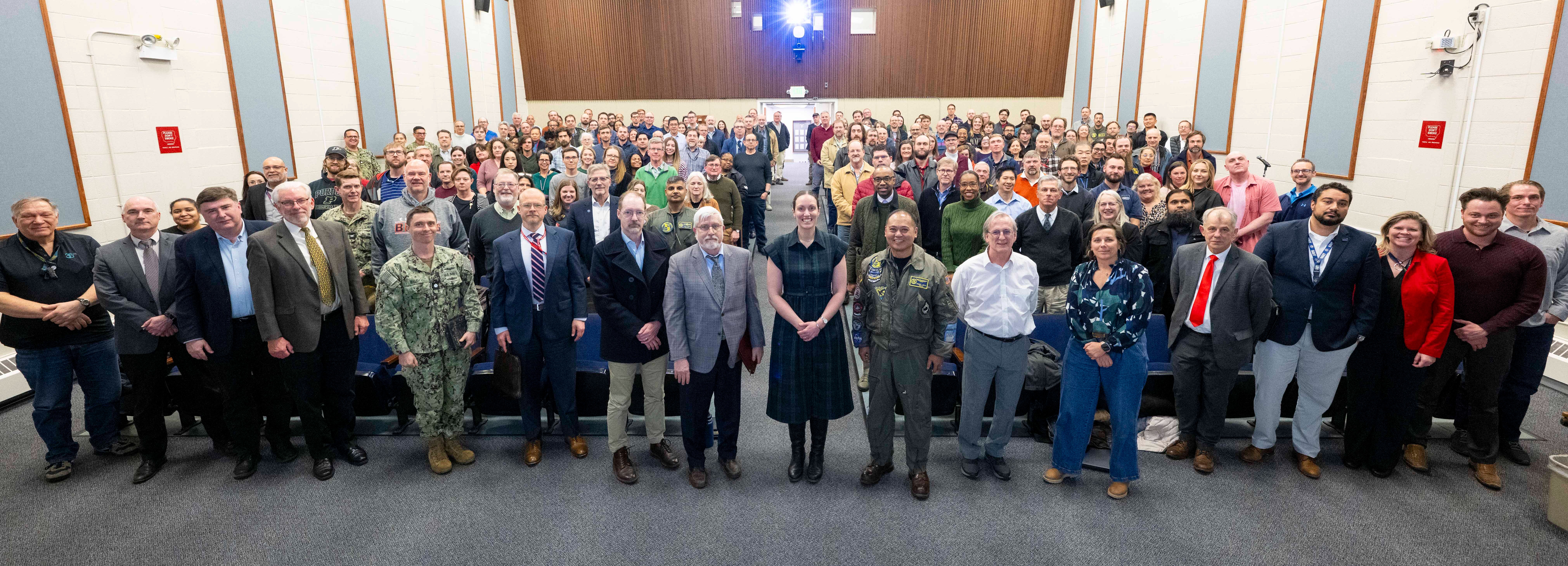 hundreds of employees stand in auditorium